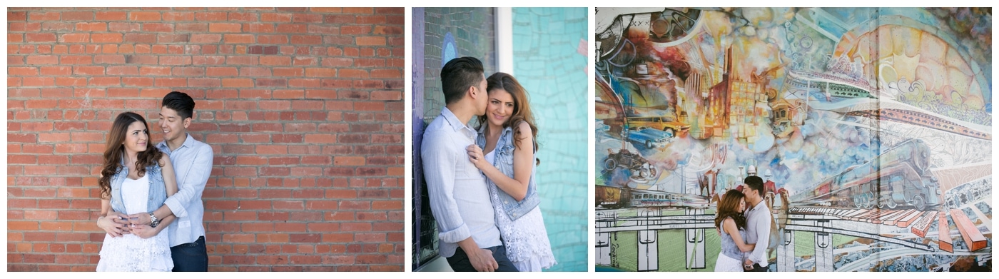 An urban engagement shoot with a couple standing in front of a brick wall and graffiti art