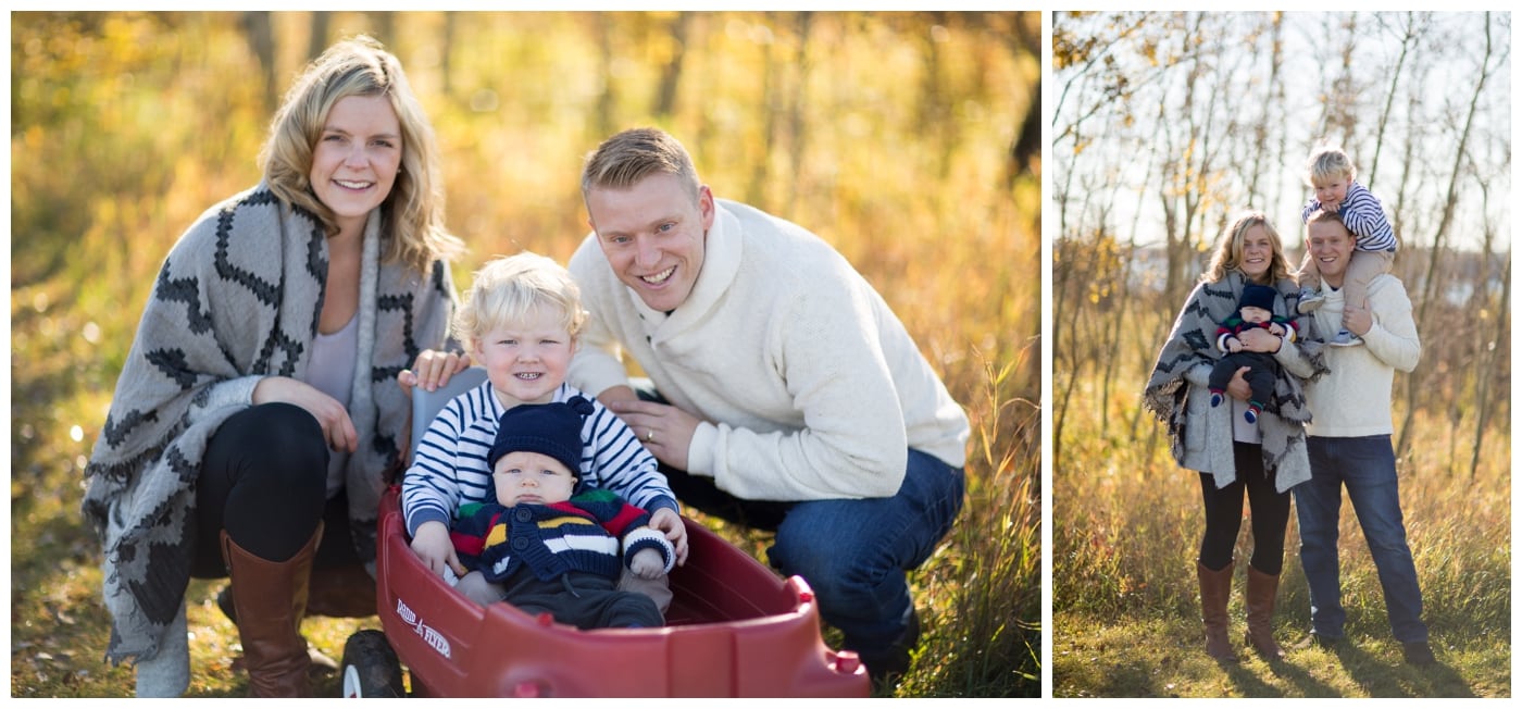 A family with two young boys pose with a red wagon and with one boy on Dad's shoulders