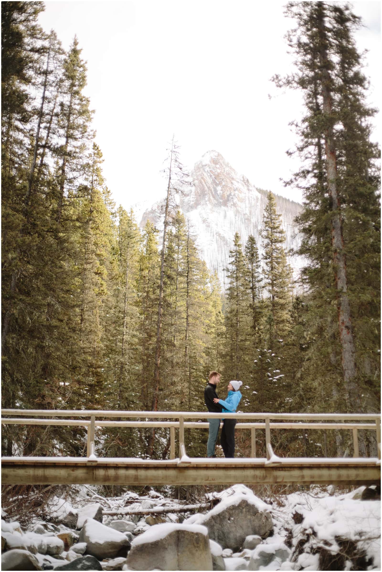 A beautiful adventure engagement session in the Rocky Mountains of Alberta at Barrier Lake, Kananaksis, and Spray Lakes with 360 mountain views and snow