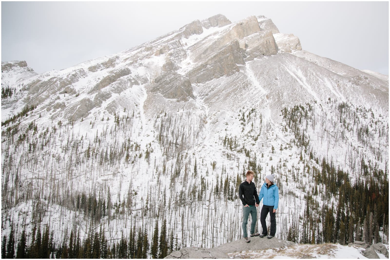 A beautiful adventure engagement session in the Rocky Mountains of Alberta at Barrier Lake, Kananaksis, and Spray Lakes with 360 mountain views and snow