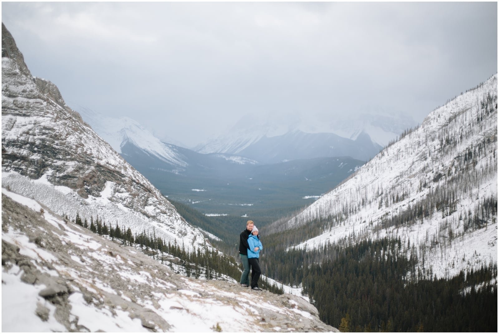 A beautiful adventure engagement session in the Rocky Mountains of Alberta at Barrier Lake, Kananaksis, and Spray Lakes with 360 mountain views and snow