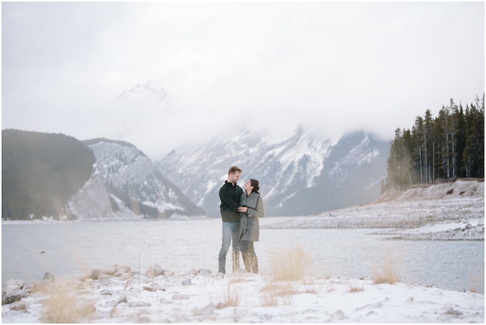 A beautiful adventure engagement session in the Rocky Mountains of Alberta at Barrier Lake, Kananaksis, and Spray Lakes with 360 mountain views and snow