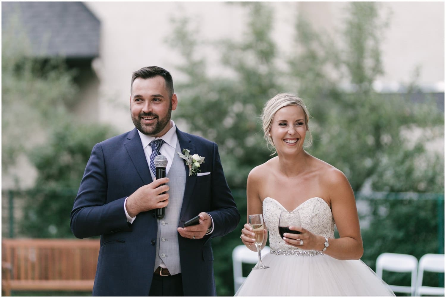 A bride and groom give a speech in their backyard at their wedding