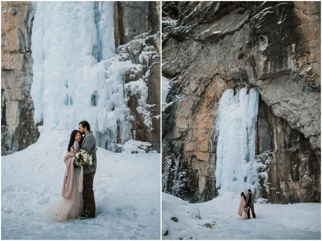 Wedding couple stands in front of a frozen waterfall in the winter