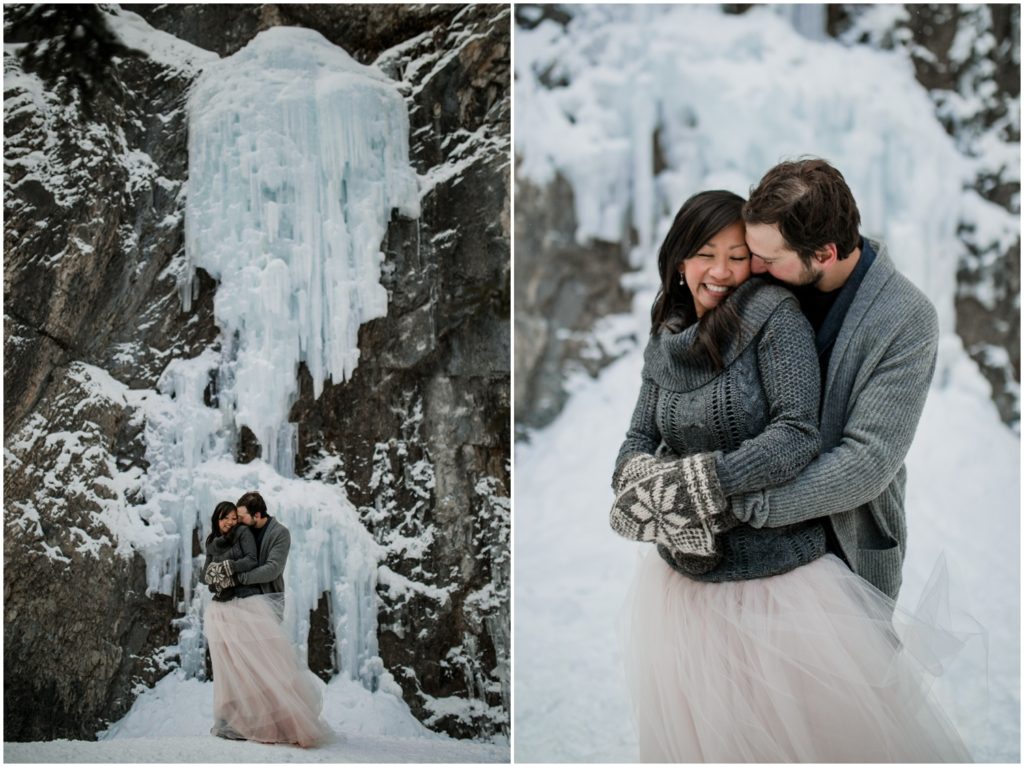 Wedding couple stands in front of a frozen waterfall in the winter