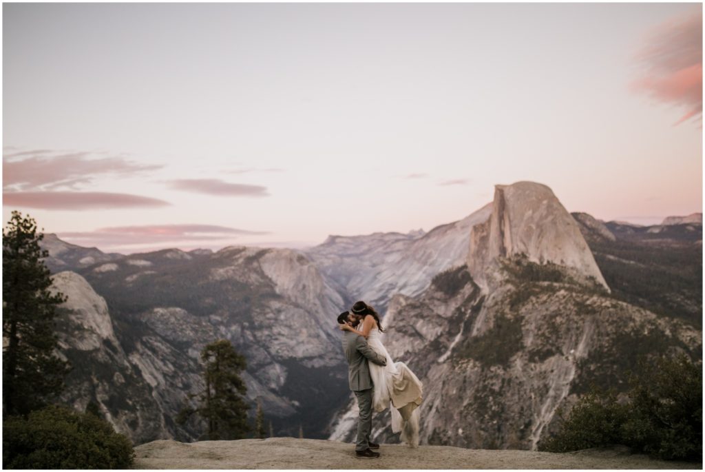 A newly wed couple embraces during sunset overlooking Yosemite National Park