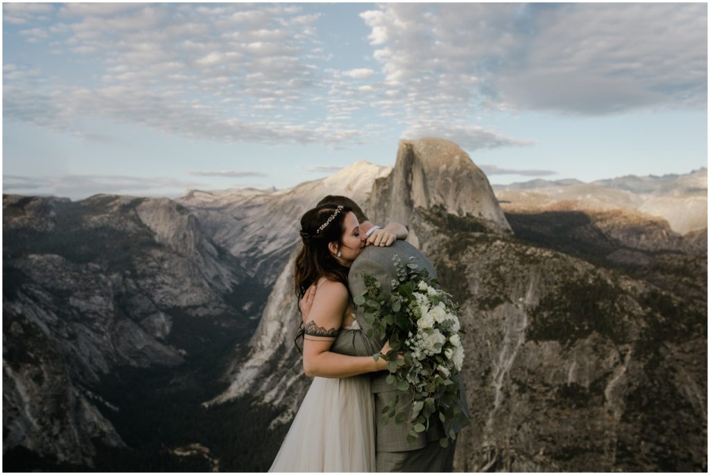 A newly wed couple embraces in front of Half Dome in Yosemite National Park