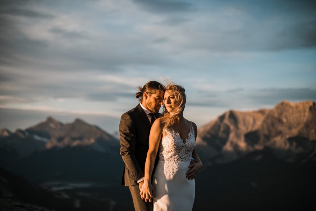 A couple embrases at sunrise during their sunrise hiking adventure elopement. 