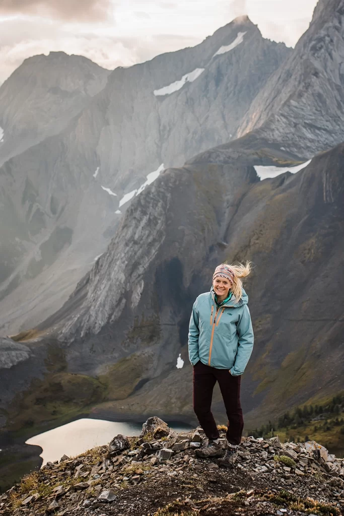 Banff elopement photographer Laura Barclay Photography stands on top of Smutwood Peak in Kananaskis at sunrise