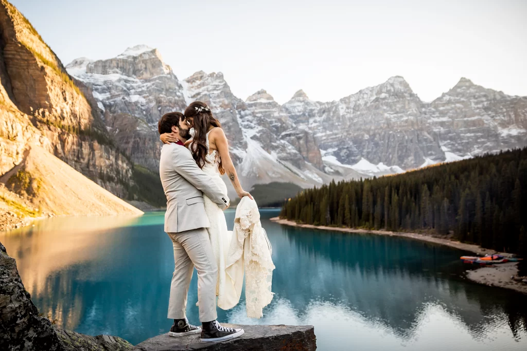 A married couple kiss while overlooking Moraine Lake in Banff National Park