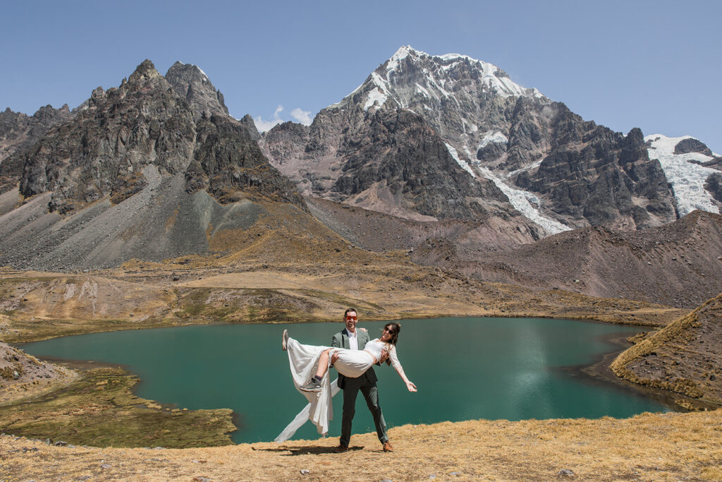 A couple poses in front of mountains on their trekking Peru adventure elopement. 