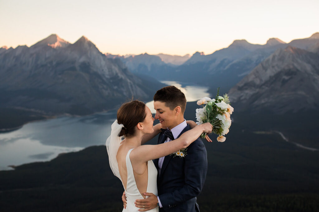 A same sex couple celebrating their love at the top of Tent Ridge in Kananaskis, Alberta during their sunrise hiking elopement. 