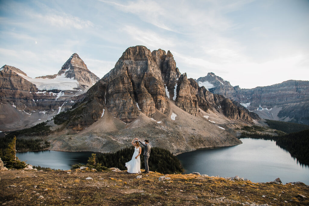 A couple stands in front of Mount Assiniboine for their backcountry camping elopement