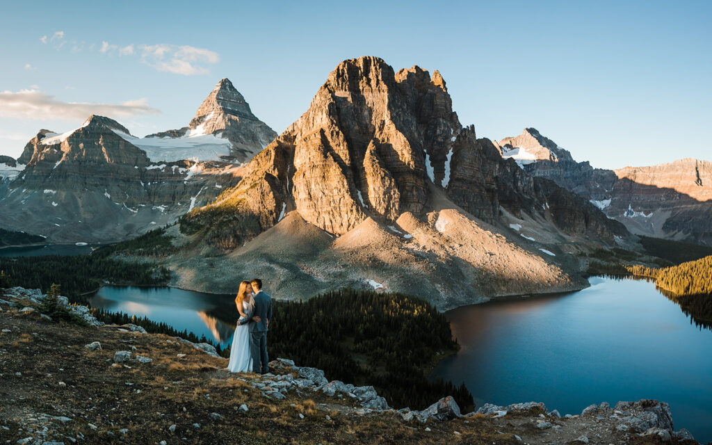 A couple stands in front of Mount Assiniboine for their backcountry camping elopement