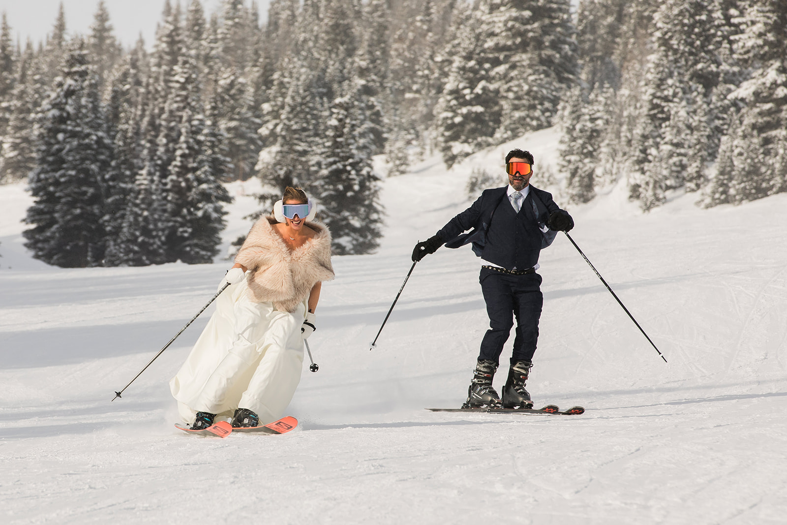A bride and groom ski down a hill during their Lake Louise ski elopement in Banff National Park